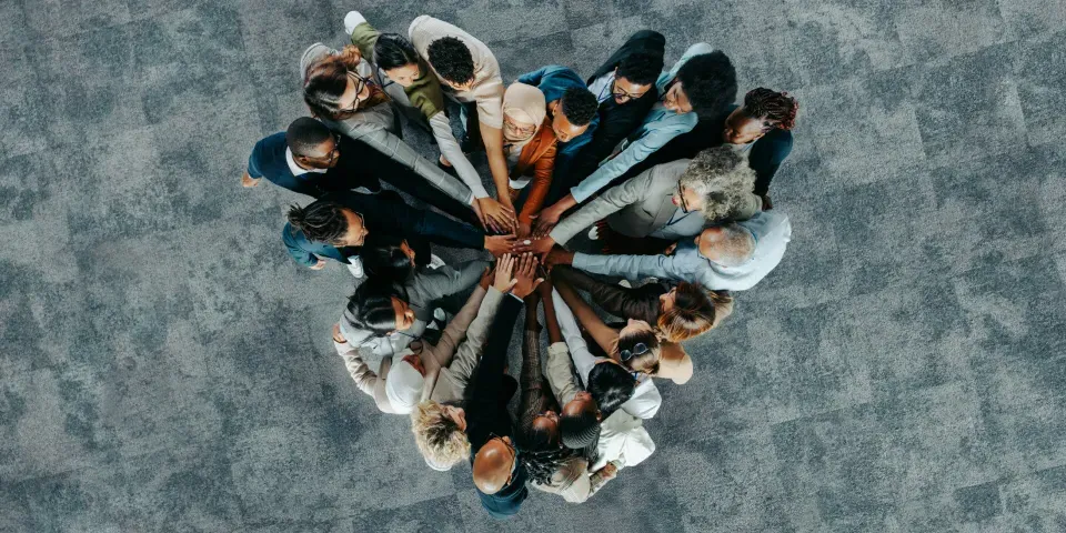 A diverse business group standing in a heart formation, symbolizing unity, teamwork, and collaboration.